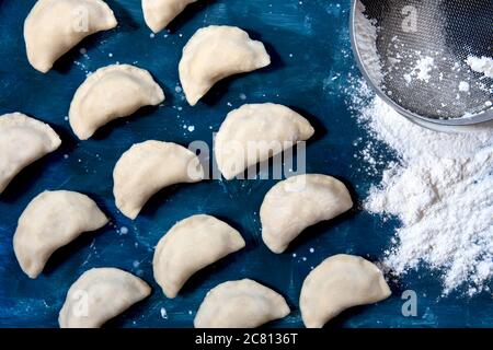 Roher Knödel mit Kartoffeln. Vorbereitung Knödel auf einem blauen Hintergrund. Stockfoto