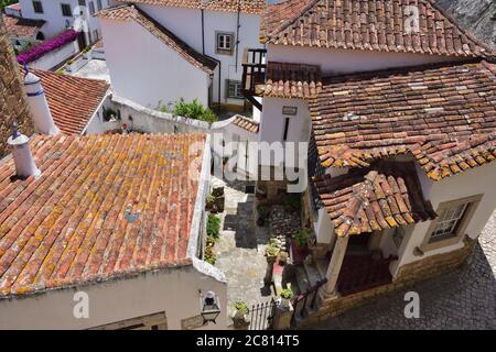 Obidos, Portugal - 1. Juni 2017: Blick von oben auf eine charmante mittelalterliche Straße der Altstadt Obidos in Portugal. Obidos ist ein beliebtes Touristenziel Stockfoto