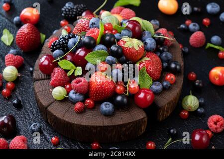 Sammlung von Waldbeeren auf schwarzem Hintergrund, Draufsicht Stockfoto