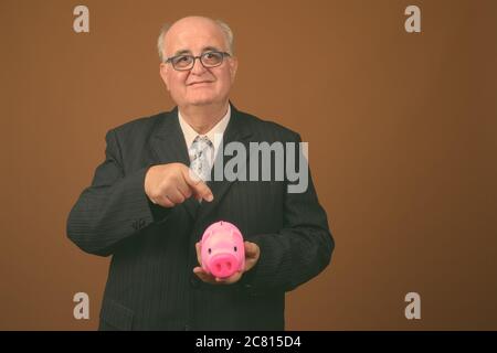 Übergewichtiger Geschäftsmann mit Brillen vor braunem Hintergrund Stockfoto