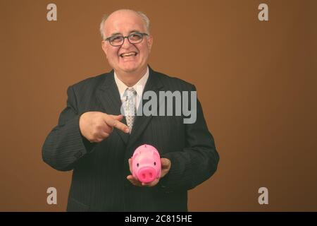 Übergewichtiger Geschäftsmann mit Brillen vor braunem Hintergrund Stockfoto