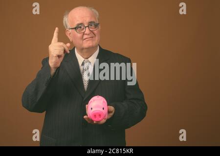 Übergewichtiger Geschäftsmann mit Brillen vor braunem Hintergrund Stockfoto