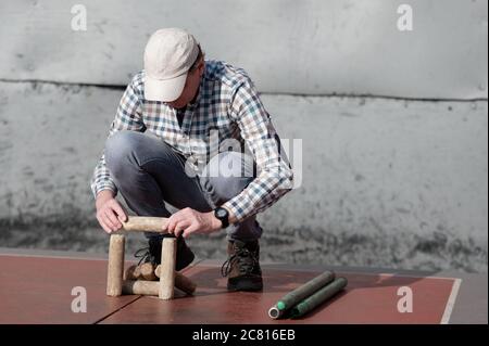 Mann spielt Gorodki, die alte russische Volkssport Stockfoto