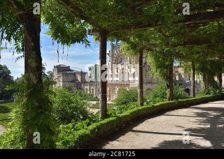 Wisteria hängt von einem Gitter über einen Pfad in den Gärten des Bussaco-Palastes bei Luso in Portugal. Palast erbaut 1628 als Kloster Stockfoto