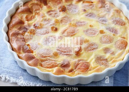 Einfach gebackene Aprikosen Clafoutis, die traditionelle französische Dessert, in einer Backform Stockfoto