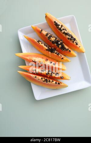Scheiben von frischen Papaya-Früchten auf einem rechteckigen Teller. Draufsicht Stockfoto