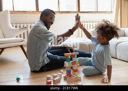 Aufgeregt biracial Vater und Sohn geben High fünf spielen Stockfoto