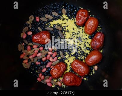 Ansicht von oben auf bunte Haferbrei Zutaten in schwarzem Hintergrund. Gemischte Cerealien und Hirse. Natürliche gesunde Ernährung Konzept Stockfoto