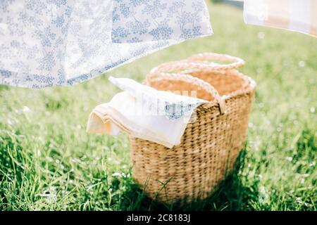 Korbkorb gefüllt mit Leinen auf dem Gras zum Waschen Stockfoto