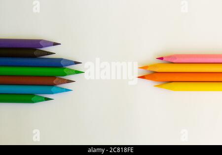 Viele Buntstifte sind auf weißem Hintergrund gegeneinander positioniert Stockfoto