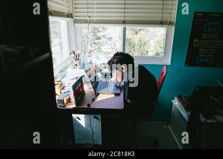 Zehnjähriger Junge, der für die Schule an einem Laptop arbeitet Während der Quarantäne Stockfoto