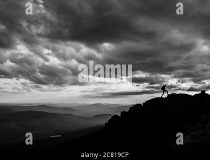 Mann geht am Gipfelgrat bei Sonnenuntergang am Berg in entlang Maine Stockfoto