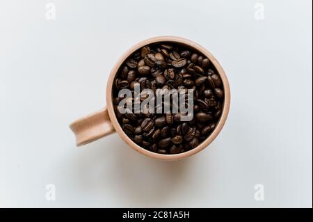 Kaffeetasse voll von ganzen Kaffeebohnen Stockfoto