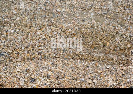 Kleine Kieselsteine und Sand Meeresboden Hintergrund Textur unter klarem Kristall seichtes Meerwasser, Draufsicht. Stockfoto