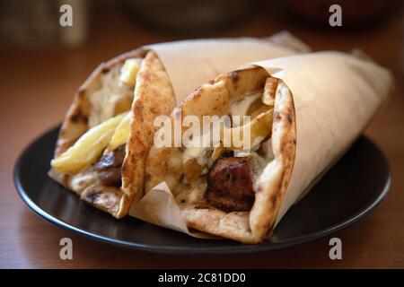 Gyros Pita, Shawarma, take away, Street Food. Zwei pita Brot Wraps mit Fleisch, traditionelle griechische türkisches Essen auf Holztisch, Nahaufnahme Stockfoto