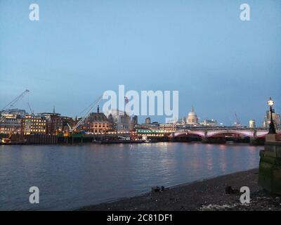 Die St. Paul's Cathedral ist direkt über der Southwark Bridge zu sehen, die sich über die Themse, London, Großbritannien, erstreckt, wenn die Abendbeleuchtung eingeschaltet wird. Stockfoto