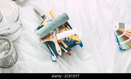 Farbe, Bauwerkzeuge und Farbpalette auf dem Boden in der Wohnung. Stockfoto