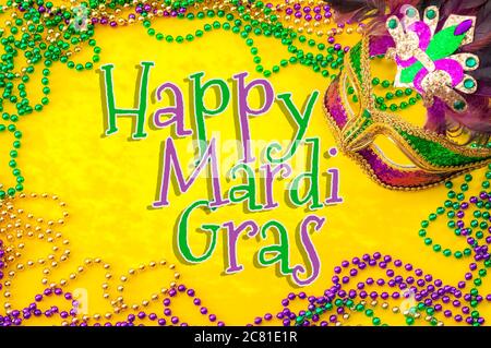 Happy Mardi Gras und Fat Tuesday Faschingskonzept Thema mit Nahaufnahme auf einer Gesichtsmaske voller Farbe, Federn und Textur und Gold, grün und lila Stockfoto