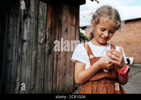 Ein Mädchen kümmert sich um die neu geborenen gelben Hühner im Hof. Kleine Farm und Streichelzoo Konzept Stockfoto