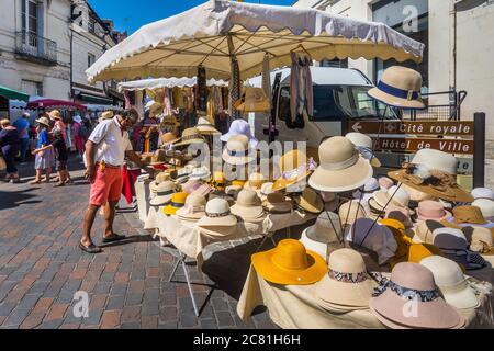 Mann, der Strohhüte im französischen Freiluftmarkt betrachtet - Loches, Indre-et-Loire, Frankreich. Stockfoto