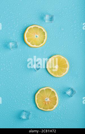 Scheiben frische Zitrone auf blauem Hintergrund mit Eis. Stockfoto