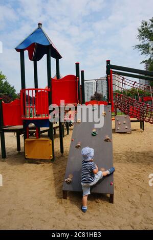 POSEN, POLEN - 20. Jul 2017: Drei Jahre altes Kind auf einer Kletterausrüstung auf einem Spielplatz im Bezirk Orla Bialego Stockfoto