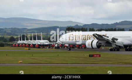 Glasgow, Schottland, Großbritannien. Juli 2020. Bild: Emirates Flug aus Dubai gesehen Landung am Flughafen Glasgow mit einer großen Gruppe von geerdeten British Airways (BA) airbus-Flugzeugen im Hintergrund. Quelle: Colin Fisher/Alamy Live News Stockfoto