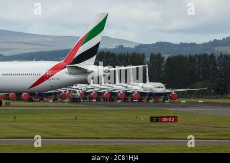 Glasgow, Schottland, Großbritannien. Juli 2020. Bild: Emirates Flug aus Dubai gesehen Landung am Flughafen Glasgow mit einer großen Gruppe von geerdeten British Airways (BA) airbus-Flugzeugen im Hintergrund. Quelle: Colin Fisher/Alamy Live News Stockfoto