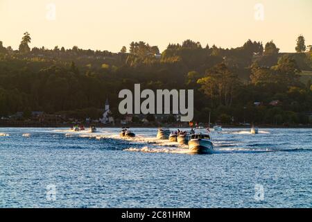 Beeindruckende Aussicht auf den See Llanquihue mit Motorbooten, die bei Sonnenuntergang segeln. Frutilllar, Lake District Stockfoto