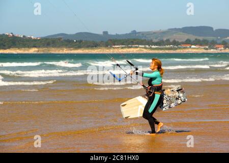 Kitesurferin oder Kiteboarderin bereitet sich auf Kitesurfen vom Strand von Somo an einem sonnigen, windigen Nachmittag vor Santander Cantabria Spanien Sommer Stockfoto