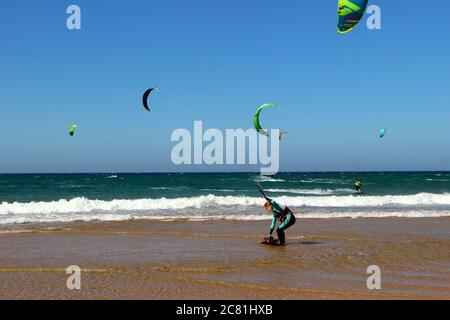 Kitesurferin oder Kiteboarderin bereitet sich auf Kitesurfen vom Strand von Somo an einem sonnigen, windigen Nachmittag vor Santander Cantabria Spanien Sommer Stockfoto