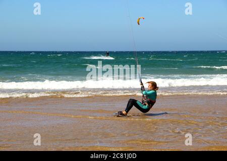 Kitesurferin oder Kiteboarderin bereitet sich auf Kitesurfen vom Strand von Somo an einem sonnigen, windigen Nachmittag vor Santander Cantabria Spanien Sommer Stockfoto