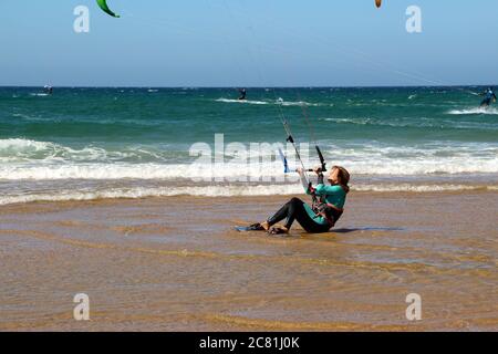 Kitesurferin oder Kiteboarderin bereitet sich auf Kitesurfen vom Strand von Somo an einem sonnigen, windigen Nachmittag vor Santander Cantabria Spanien Sommer Stockfoto