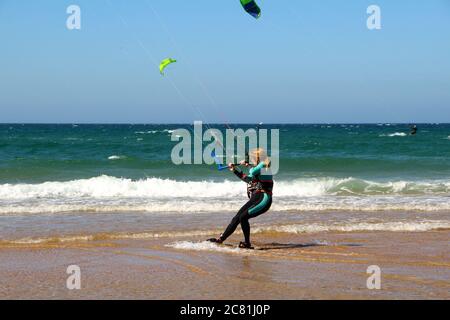 Kitesurferin oder Kiteboarderin bereitet sich auf Kitesurfen vom Strand von Somo an einem sonnigen, windigen Nachmittag vor Santander Cantabria Spanien Sommer Stockfoto