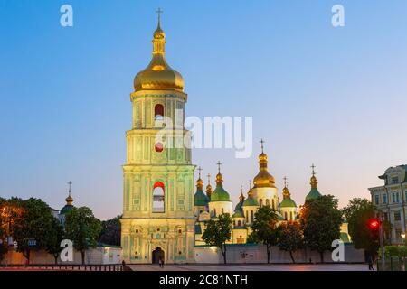 Hagia Sophia-Kathedrale mit Blick auf den Glockenturm in der Dämmerung, blühende Kastanienbäume und Nachglimmhimmel im Hintergrund, Kiew, Ukraine Stockfoto