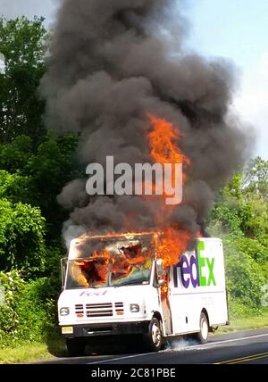 Ein FedEx-LKW brennt am Straßenrand mit Flammen und Rauch Stockfoto