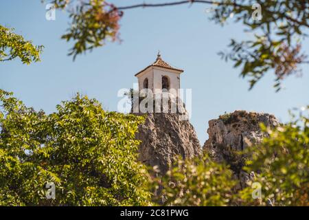 Faszinierende Aufnahme eines berühmten Glockenturms auf dem Felsen bei der Burg Guadalest in Alicante, Spanien Stockfoto