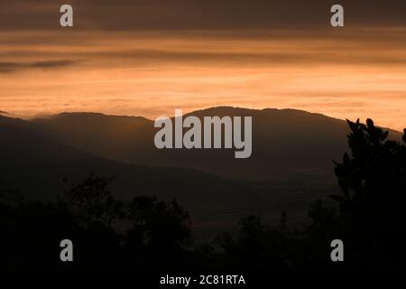 Hohe Berge leuchten unter den bunten Wolken Stockfoto