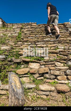 Ein männlicher Tourist klettert die steilen Steintreppen in Tonina, der präkolumbianischen archäologischen Stätte und Ruinenstadt der Maya-Zivilisation; Chiapas, Mexiko Stockfoto