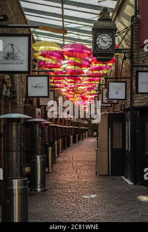 Bunte Allee von Sonnenschirmen hängen in den berühmten Camden Stables in London. Stockfoto