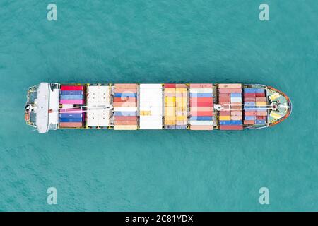 Ansicht von oben, atemberaubenden Blick auf ein Schiff segeln mit Hunderten von farbigen Behälter direkt in den Hafen von Singapur. Stockfoto