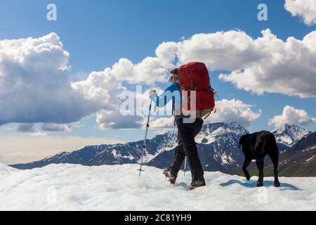 Frau und ihr Hund beim Rucksackwandern auf dem Kennicott Gletscher, Wrangell Mountains, Wrangell-St. Elias National Park, Süd-Zentral Alaska Stockfoto