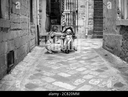 Kotor, Montenegro, 22. Sep 2019: Frau mit Baby auf der Kopfsteinpflasterstraße der Altstadt von Kotor Stockfoto