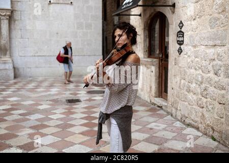 Montenegro, 22. Sep 2019: Frau spielt Geige auf dem Platz in der Altstadt von Kotor Stockfoto