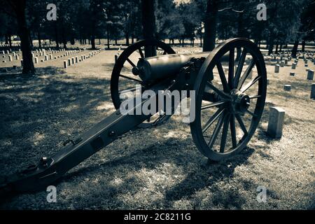 Ein Kanonenrelikt aus dem amerikanischen Bürgerkrieg überblickt den Stones River National Cemetery in Murfreesboro, TN< USA, in Sepia Stockfoto