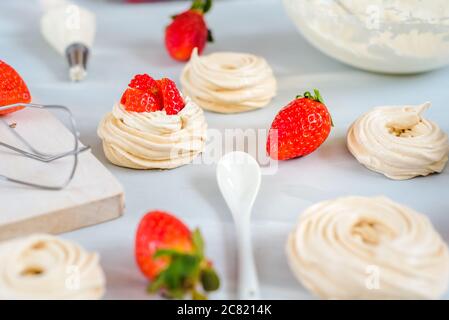 Erdbeere pavlova Kuchen Nester, Baiser Dekoration auf eine kulinarische Tabelle Stockfoto