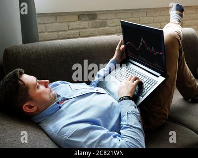 Ein Mann zu Hause analysiert den Handel an einer Online-Börse. Stockfoto