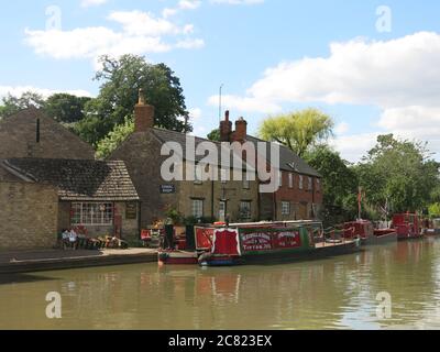 Hübsche Postkartenansicht von festgeschlemmten Schmalbooten im Kanaldorf Stoke Bruerne am Grand Union Canal in Northamptonshire. Stockfoto