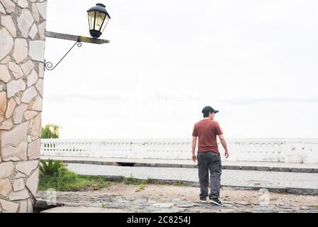 Junge männliche Touristen in Saint Gabriel Flussufer Spaziergang, in Colonia del Sacramento, Uruguay. Stadtlandschaft, ein Sommer bewölkt Tag. Stockfoto