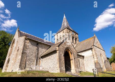 All Saints Pfarrkirche in East Meon an einem Sommertag. Beeindruckendes Steingebäude mit blauem Himmel. Stockfoto